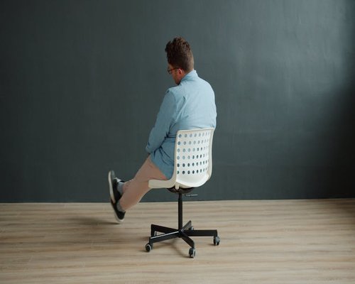 Person adjusting posture in home office chair