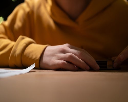 Details of hands resting on a desk